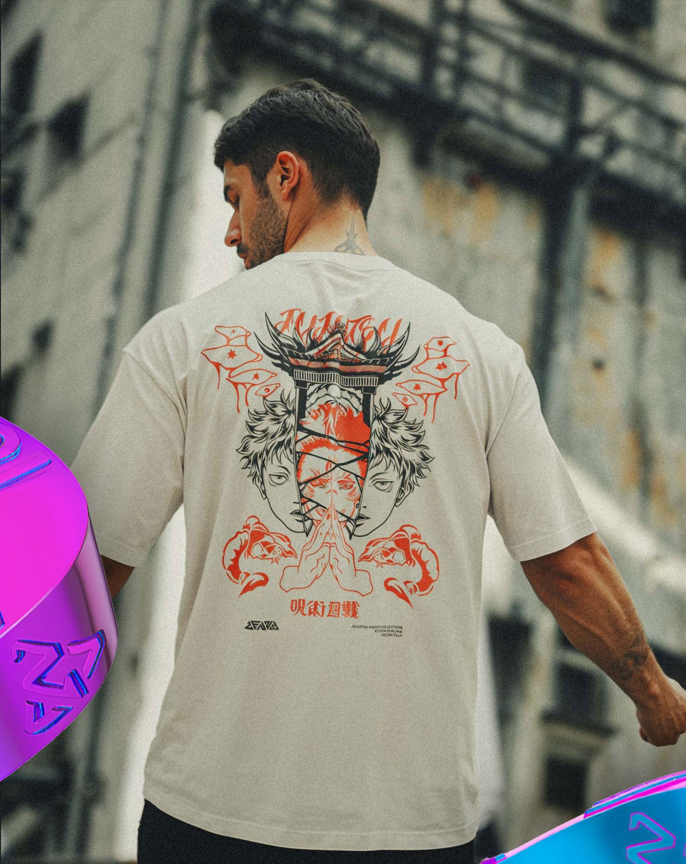 Man wearing a beige anime-inspired streetwear t-shirt featuring a bold red and black back graphic of twin faces and hand symbols, relaxed oversized fit from Torazen’s bestselling collection.