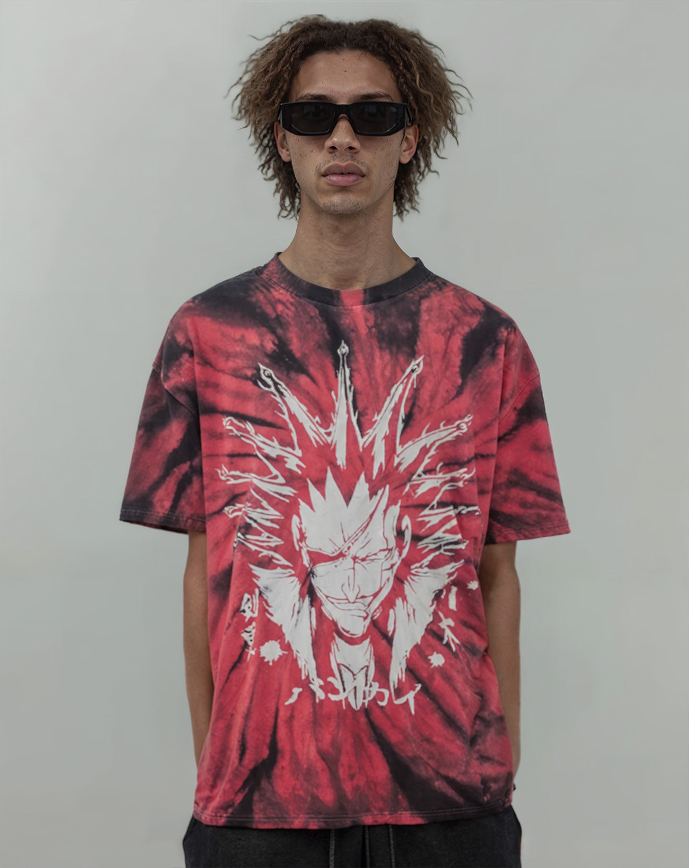 Man wearing a red and black tie-dye anime-inspired streetwear t-shirt featuring bold spiked hair character artwork on the front, relaxed oversized fit from Torazen’s Kenpachi Zaraki Tee.