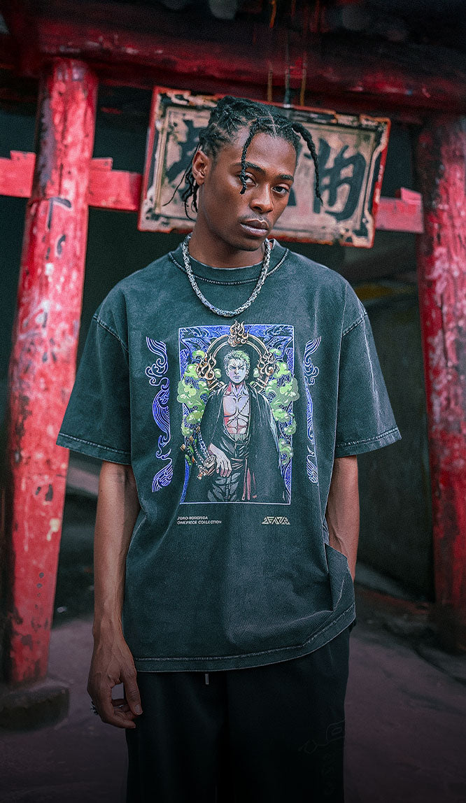 Man wearing a black vintage washed anime-inspired streetwear t-shirt featuring a detailed green and gold character illustration on the front, relaxed oversized fit from Torazen’s Energy in Every Last Thread collection.