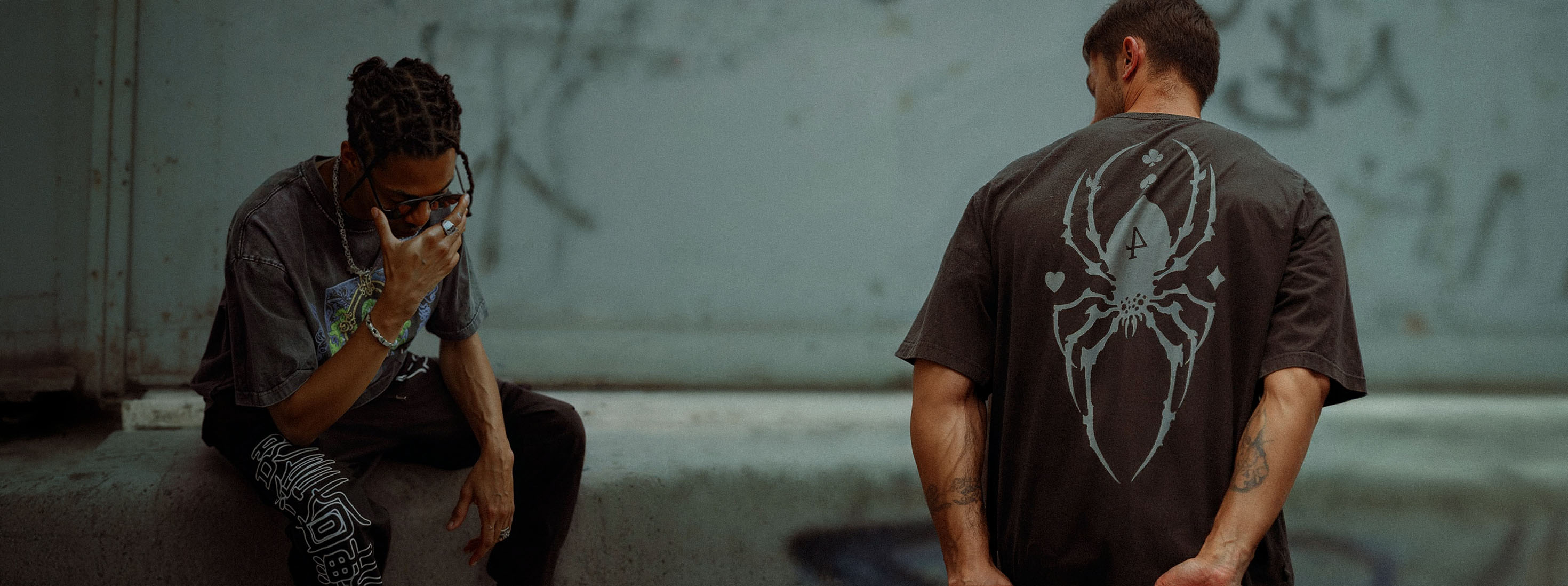 Two men wearing vintage washed anime inspired streetwear graphic tees from Torazen, showcasing bold back design and relaxed streetwear fit.