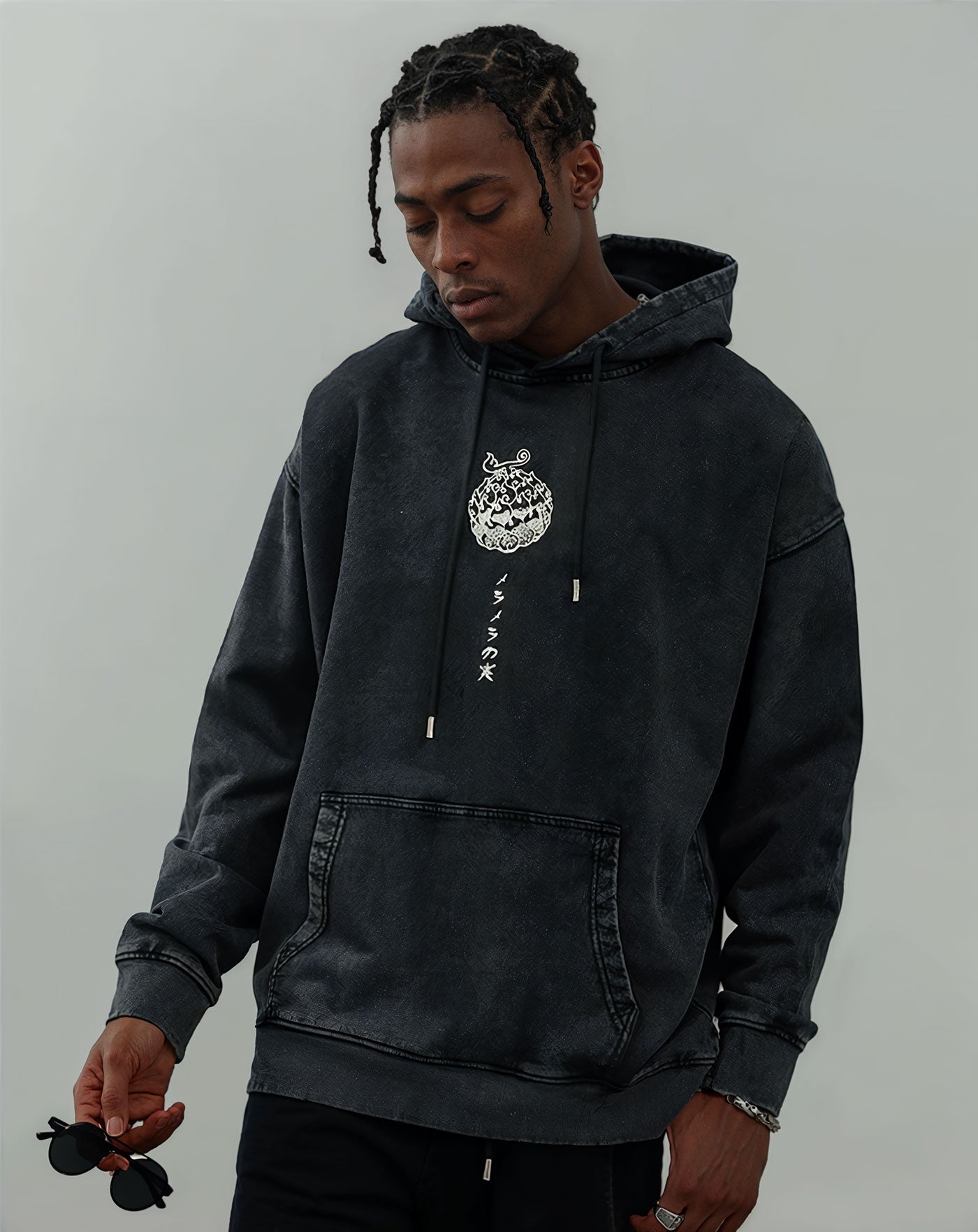 Man wearing a black vintage washed anime-inspired streetwear hoodie featuring a small front white graphic print, relaxed oversized fit from Torazen’s Whitebeard Legacy Hoodie.
